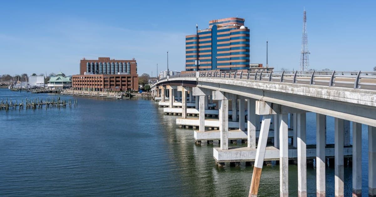 View of Hampton Harbor with prominent bridge and waterfront buildings on a clear day.