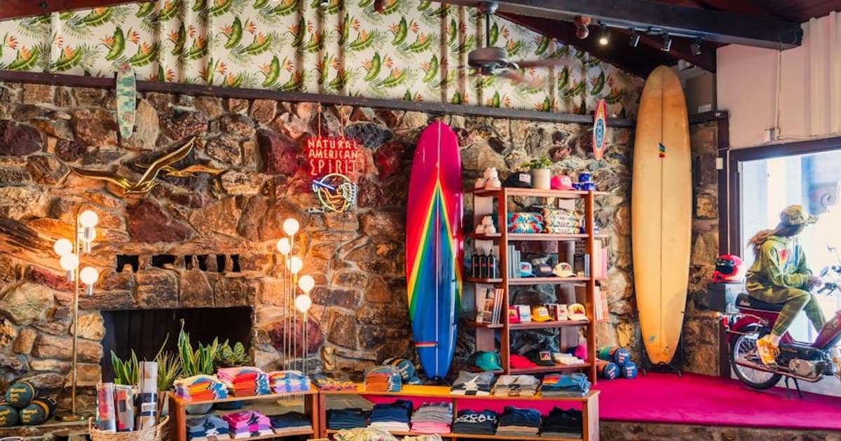 Colorful surf shop interior in Malibu with surfboards and vibrant clothing on display.