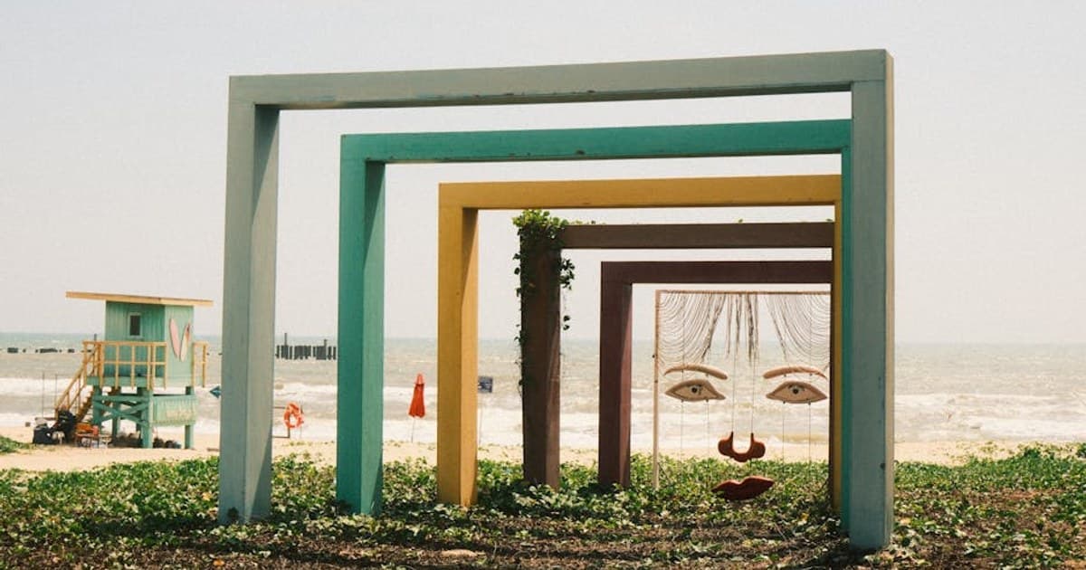 Colorful geometric frames on a beach in Phan Thiet, Vietnam, with ocean backdrop.