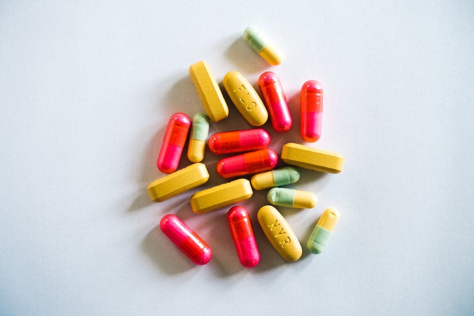 A vibrant assortment of various pills and capsules on a light background, showcasing pharmaceutical diversity.