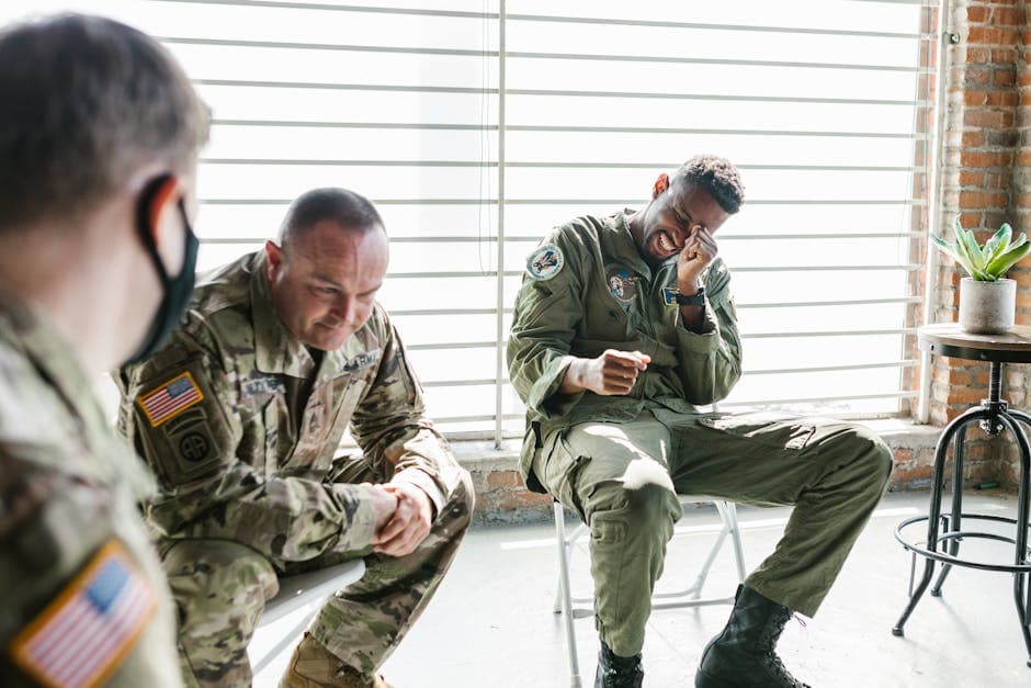 Veterans share a light moment during a group therapy session, indoors.