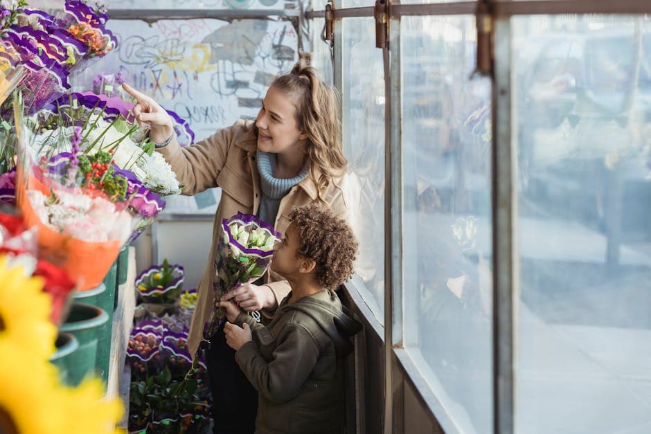 A woman and a child selecting vibrant flowers in a flower shop, enjoying a bonding moment.