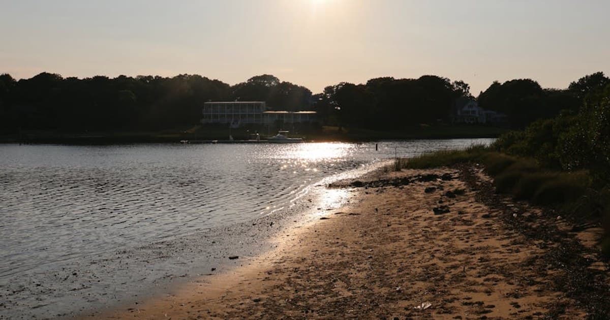 Captivating view of a sunset over a serene sandy beach in Hampton Bays.